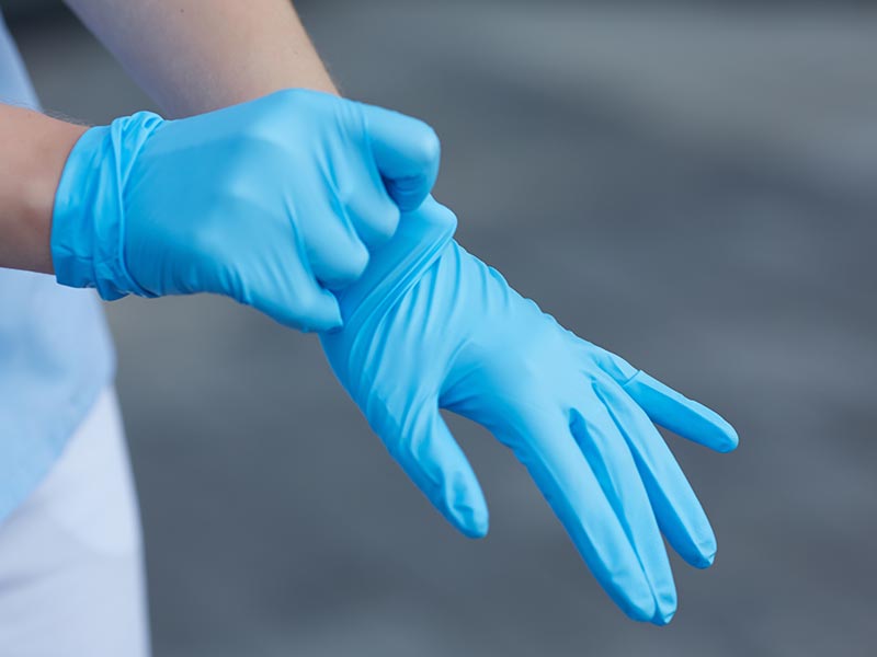 person with blue surgical gloves